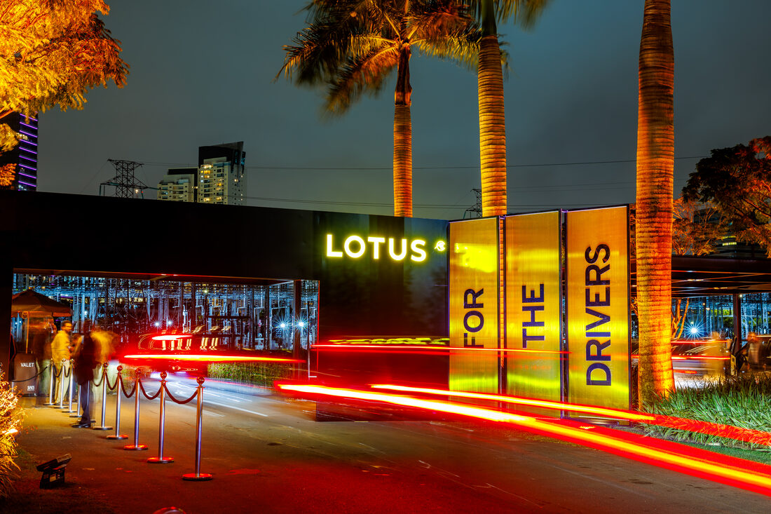 Entrada do evento com palmeiras e rastros de luz dos carros