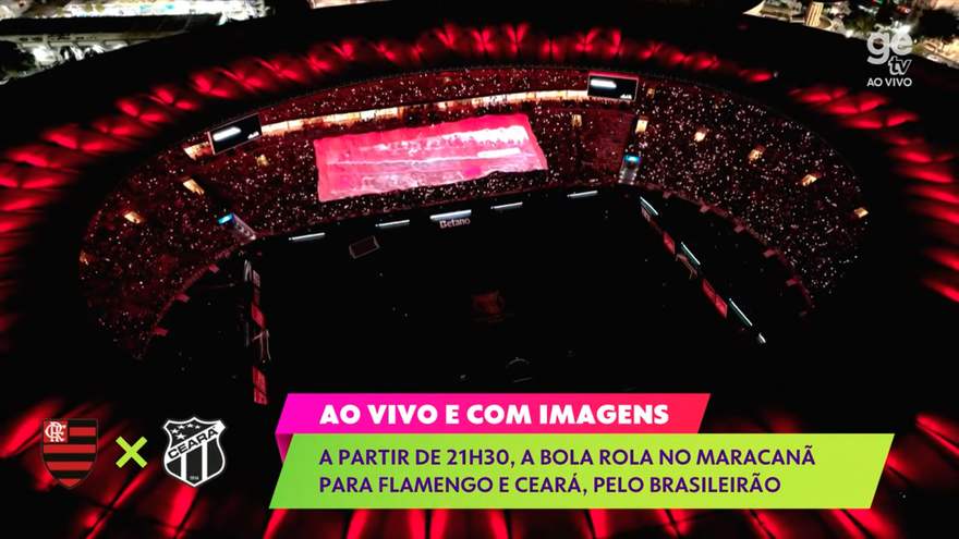 Cobertura ao vivo da GE TV no gramado com o bandeirão ao fundo