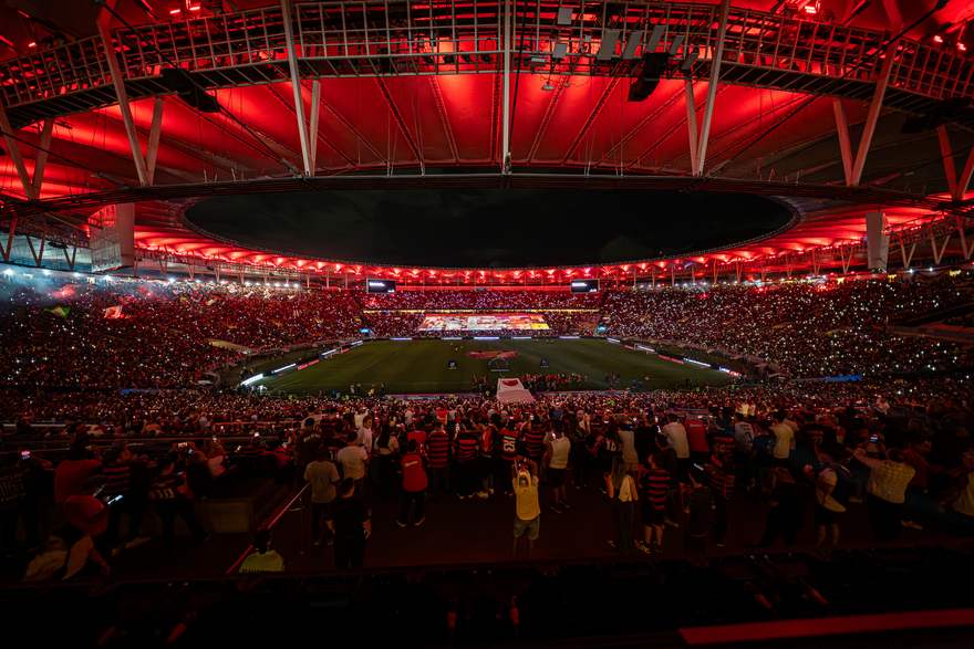 Colagem de artes da Nação projetada no bandeirão com o estádio em festa